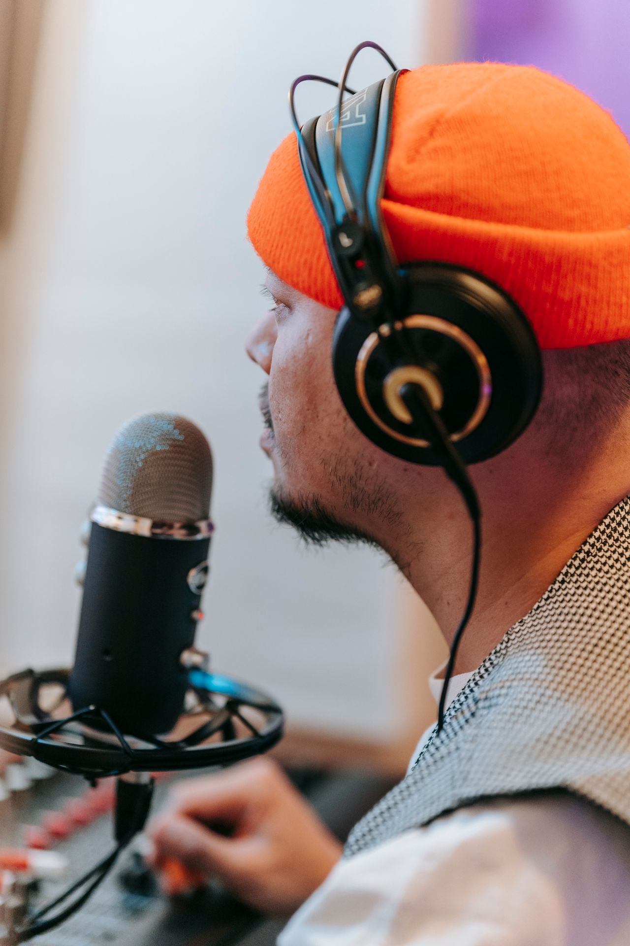 Creator wearing headphones and speaking into a studio microphone during a recording session